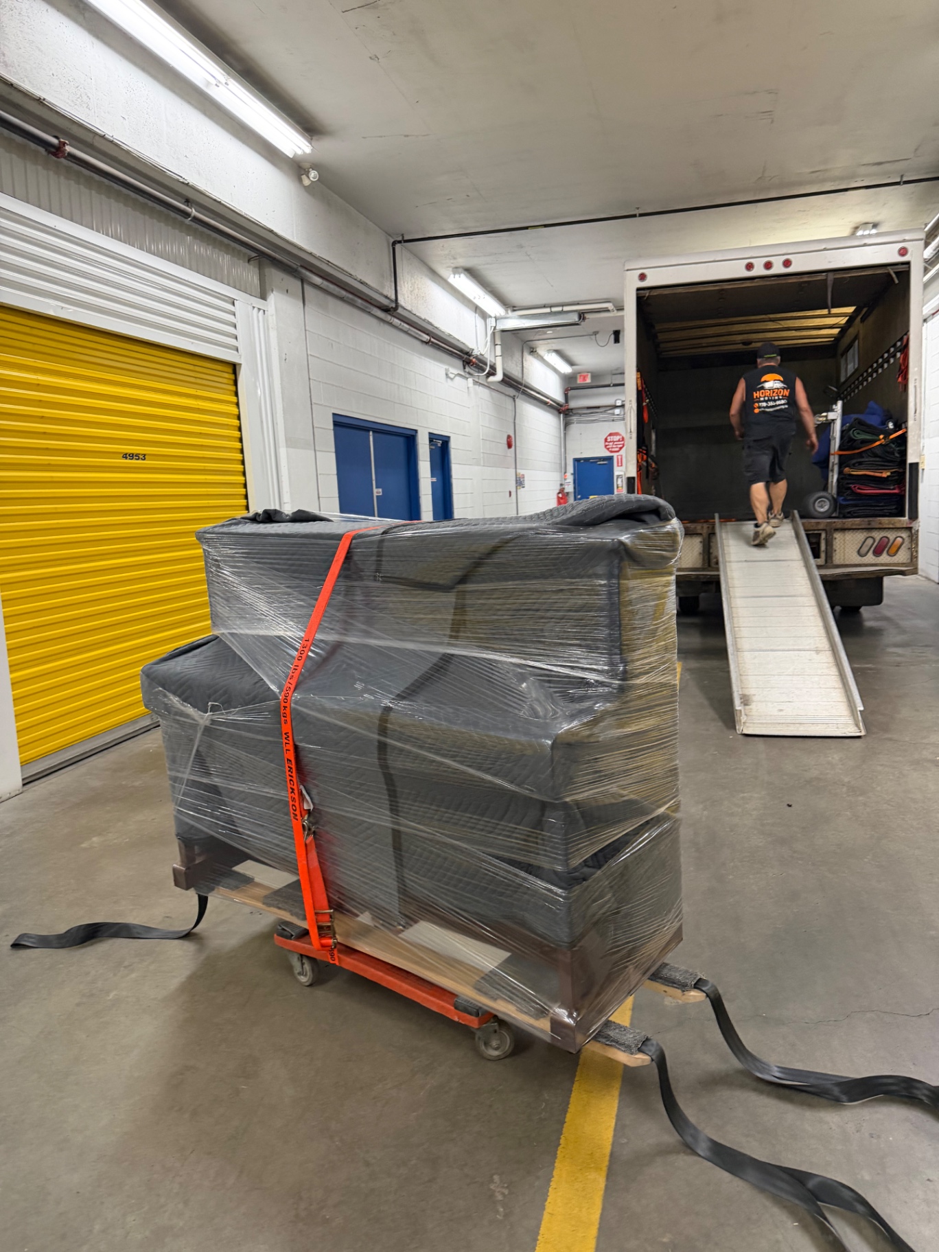 Wrapped and strapped furniture being loaded at a Kelowna storage facility