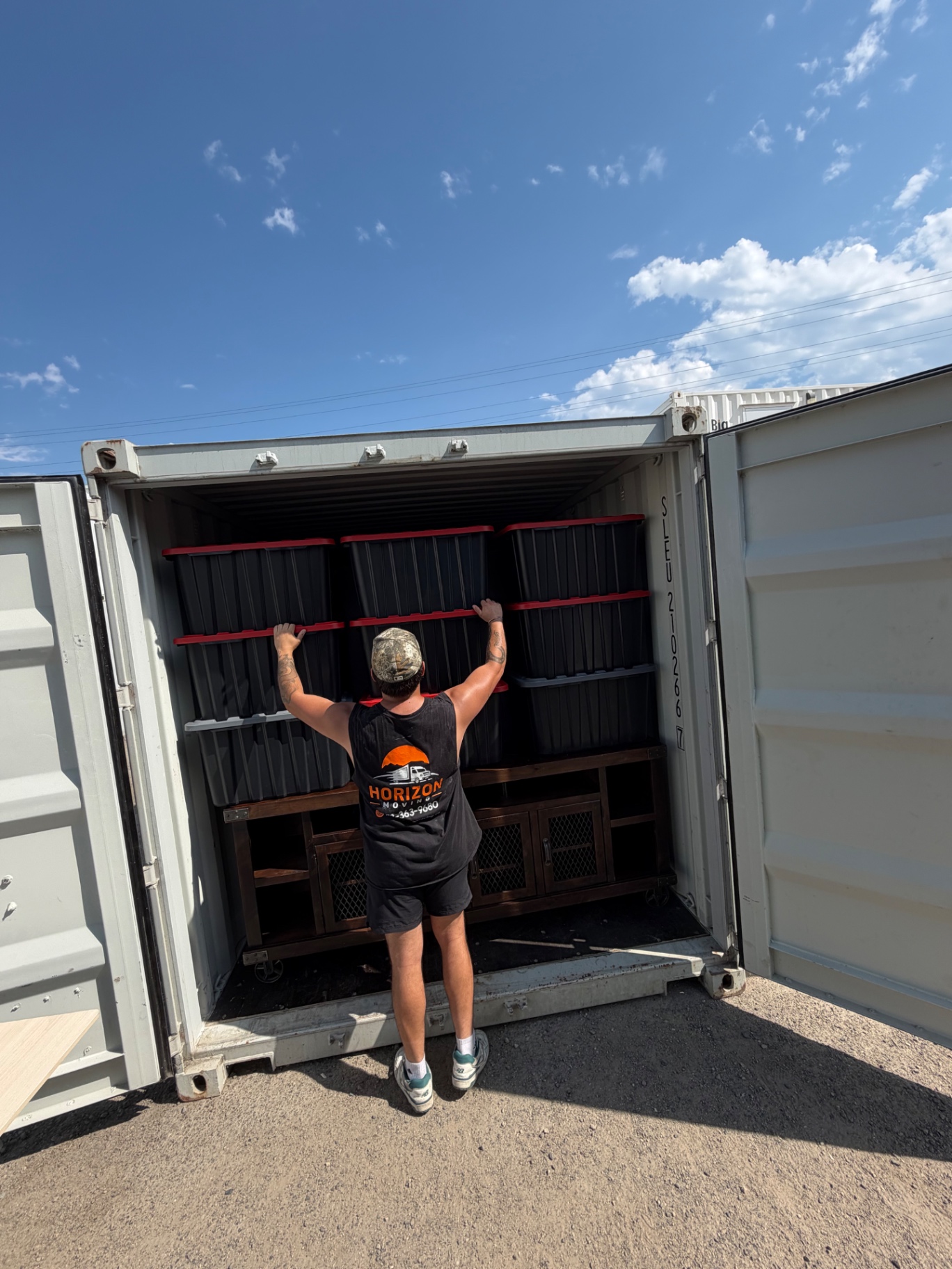 Kelowna mover organizing storage totes inside a secure shipping container