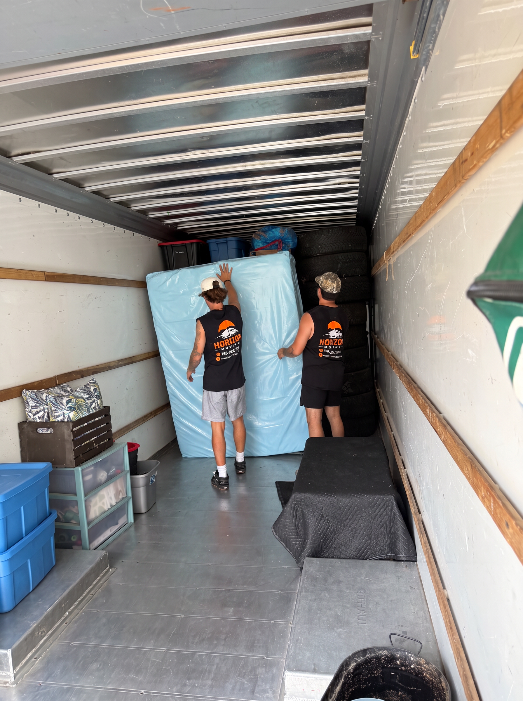 Horizon Moving crew loading a protected mattress into a moving truck in Kelowna
